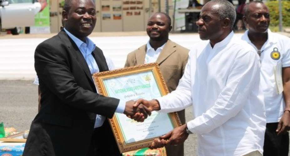 Max Fugar(left) receiving the award from Roads Minister Collins Dauda