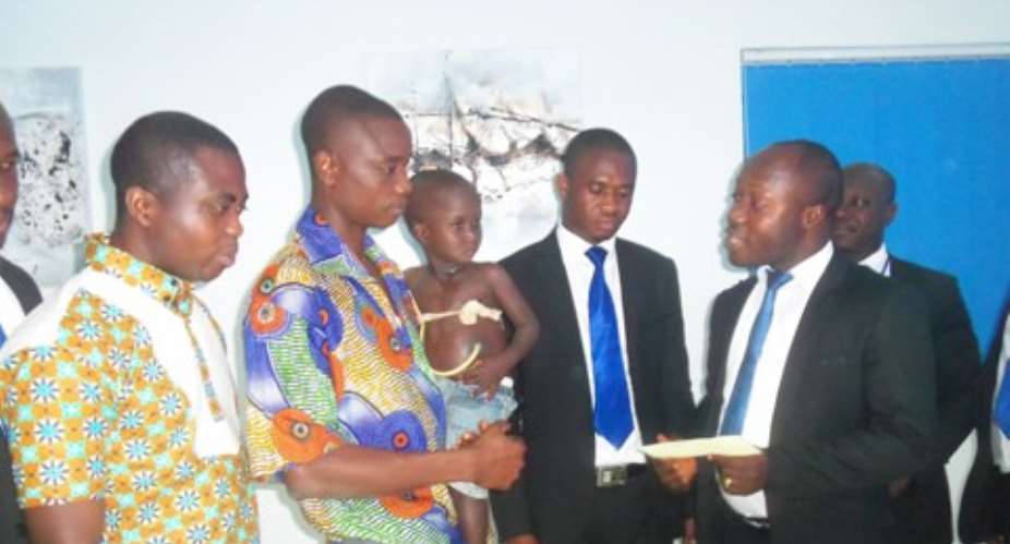 Mr. Owusu-Afriyie presenting the cheque to father of the victim, Razak Anaba.