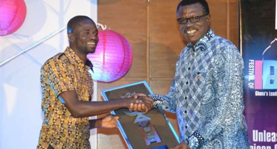 Manesseh Azure Awuni left being presented with an award by Dr. Mensa Otabil