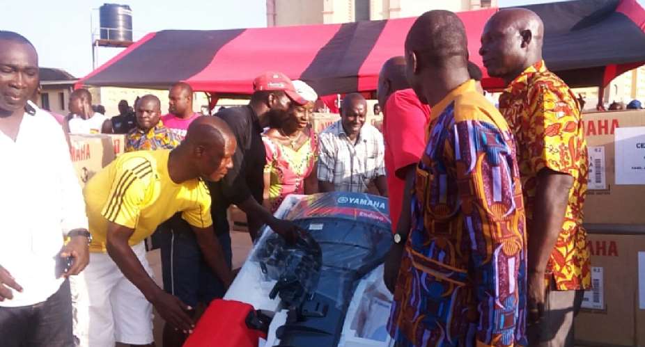 Mrs. Sherry Ayittey presenting an outboard motor to a beneficiary