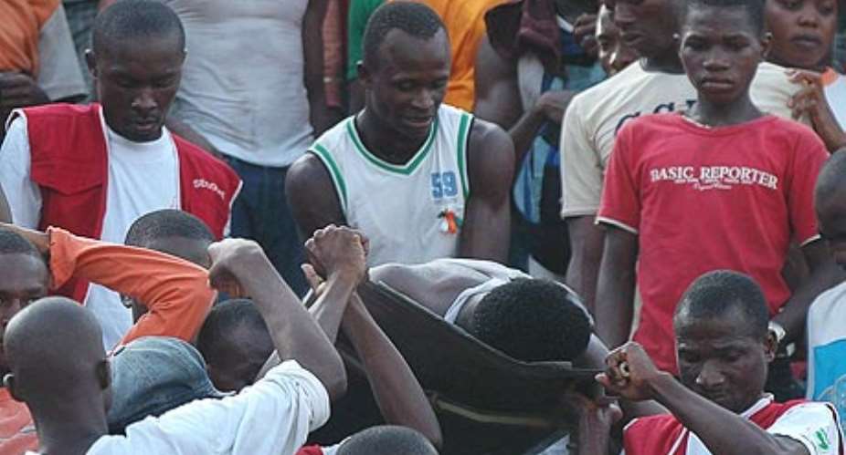 Football fans carry a spectator hurt in the stadium stampede in Abidjan yesterday. Photograph: Legnan Koula/EPA