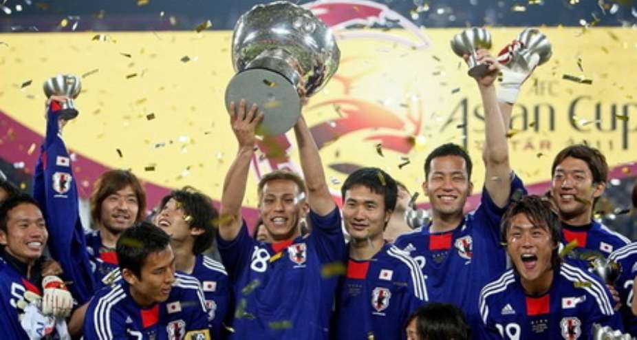 Midfielder Keisuke Honda lifts the trophy, joined by teammates to celebrate the victory