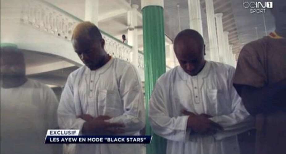Jordan Ayew, left, with brother Andre Ayew, second from right, praying