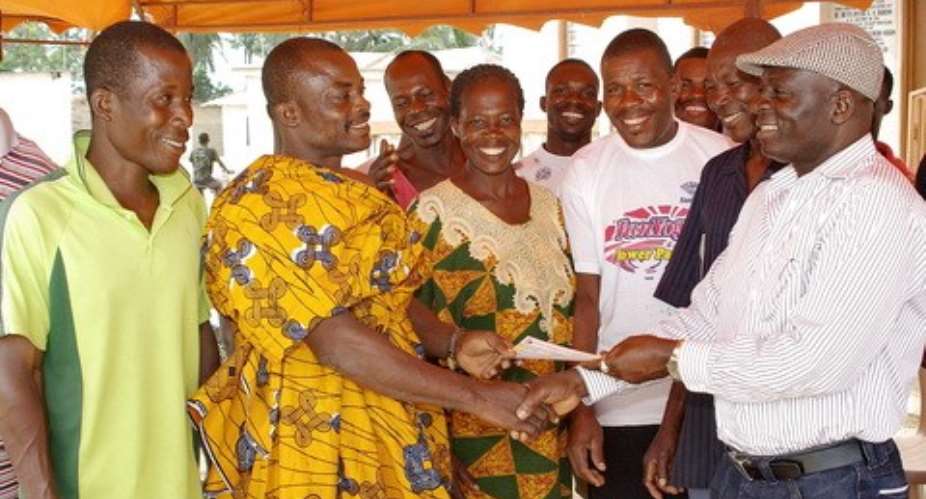 Hon. Kuntu Blankson, right presenting the cheque to Nana Kweku Badu, Ag regent of the village and his people.
