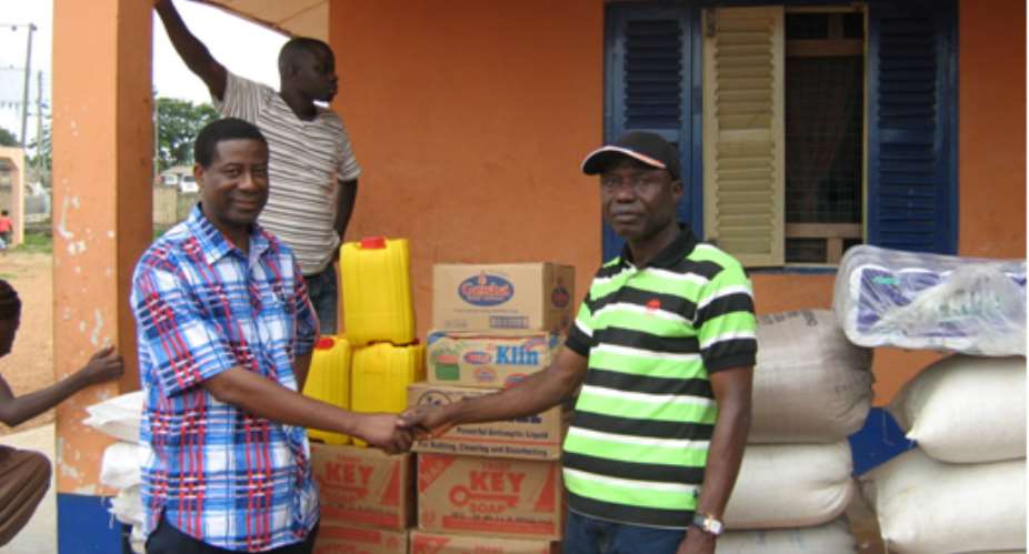 Mr. Obed Komla Adore of GCNAO in a hand-shake with Mr. Peter Uka Beidu in cap- manager of Adullam Orphanage in front of some of the donated items.