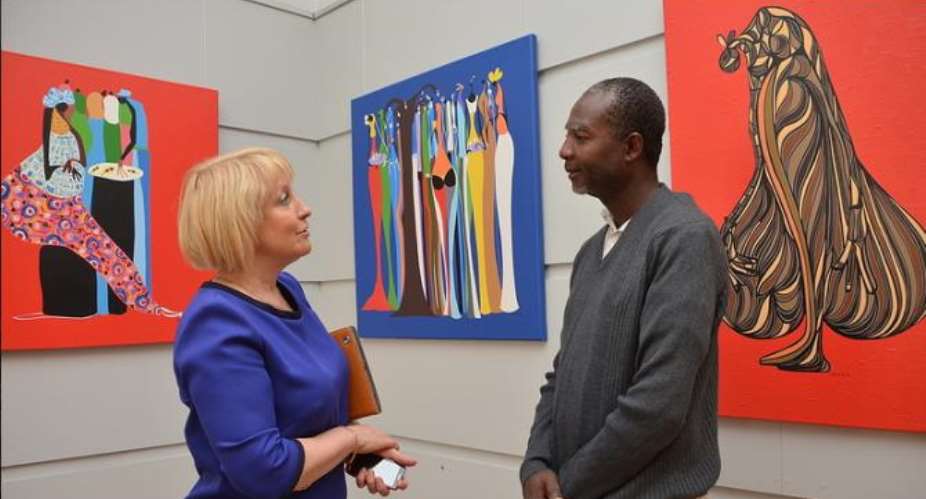 Larry Otoo talking with a participant during the first exhibition held in June