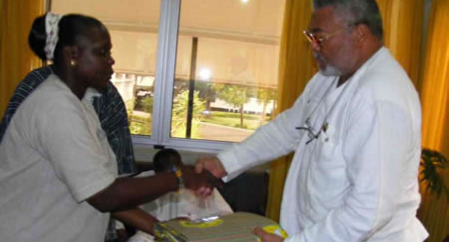 President Rawlings receiving the anniversary cloth from Justine Owusu Banahene