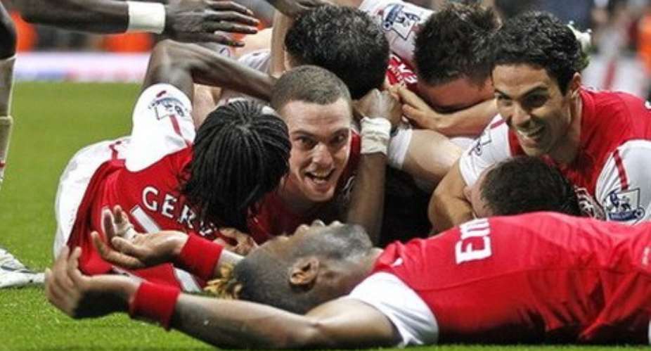 It's all over as Arsenal players bathe in the joy of the 'killer' goal that won the day.