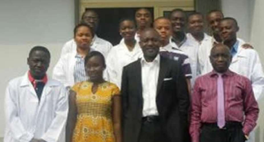 Mr. Yirenkyi in suit and Mr. Sakyiamah right in a group photograph with some of the interns and heads of department