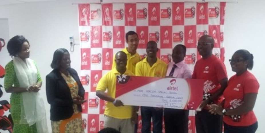 Airtel officials in red presents cheque to student from New Horizon School