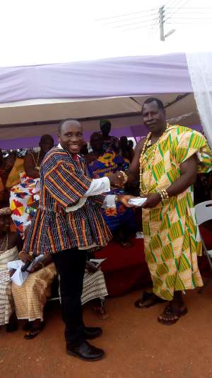 Ellembelle DCE presenting the cash to Awulea Amihere Kpanyinli Educational Scholarship