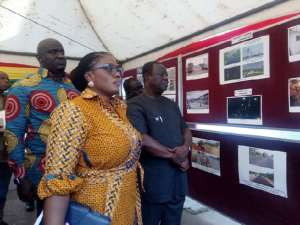 Kwasi Amoako-Atta (left), Deputy Minister of Roads, Anthony Karbo (right) and Deputy Minister of Information, Ama Dokuaa Asiamah Agyei, observing photos of some ongoing and completed roads and bridge projects shortly before the press conference