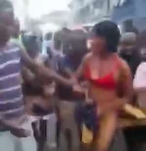 The clothes of the suspected thief being torn off her