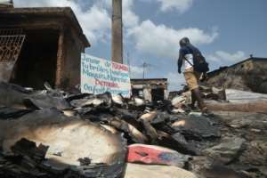 The aftermath of the violence in the city of Toumodi, in central Ivory Coast.  The sign reads: 'Toumodi youth, you burn down shops, restaurants, markets ... tomorrow, how do we manage?'  By SIA KAMBOU (AFP)