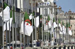 The Algerian national flag flies at half mast in the capital Algiers before Bouteflika's funeral.  By RYAD KRAMDI (AFP)