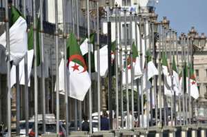 The Algerian national flag flies at half-mast in the capital Algiers ahead of Bouteflika's funeral. By RYAD KRAMDI (AFP)