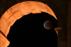 The full moon during a 'blood moon' eclipse behind the ancient Colosseum in Rome in July, 2018.  By Tiziana FABI (AFP/File)