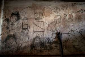 The hand of a young South Sudanese refugee at a camp in DR Congo is seen on a wall filled with drawings and writings depicting scenes from home (2019 file picture). By JOHN WESSELS (AFP/File)