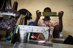The ICRC buys some 500 face masks a week from inmates who work as tailors. By MICHELE CATTANI (AFP)