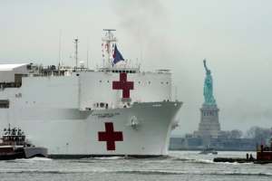 The USNS Comfort medical ship moves up the Hudson River past the Statue of Liberty as it arrives in New York. By Bryan R. Smith (AFP)