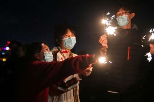 The virus surges dampened New Year's celebrations around the world.  By ANDY BUCHANAN (AFP)
