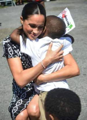Time for a hug: 'I am here as a mother, a wife, a woman of colour and your sister,' Meghan told the cheering crowd. By Courtney AFRICA (POOL/AFP)