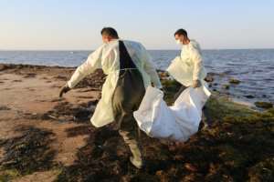 Tunisian civil protection officers recover the body of an African migrant drowned near the town of Zarzis, in the east of the country. By FATHI NASRI (AFP)