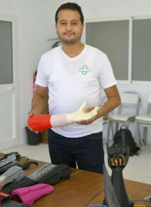 Tunisian engineer Mohamed Dhaouafi, who launched his start-up in 2017 from his parents' home, holds a prototype of an artificial hand. By Bechir TAIEB (AFP)