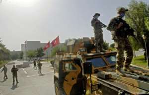 Tunisian soldiers cordon off the parliament, which was suspended by President Kais Saied on Sunday, prompting allegations of a