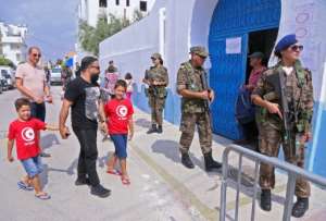 Tunisian soldiers stand guard outside a polling station as voters arrive to cast their ballots in Sousse on Sunday. By ANIS MILI (AFP)
