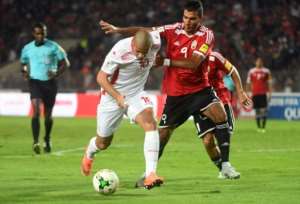 Tunisia's Wahbi Khazri (L) is marked by Libya's Mohamed Al Ghanodi (R) during a World Cup qualification football match at Rades Olympic Stadium in Tunis on November 11, 2017