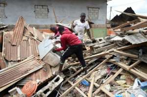 Victims try to salvage belongings trapped in the rubble of a house destroyed by the explosion. By PIUS UTOMI EKPEI (AFP)