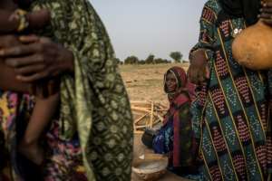 Women of the Wodaabe, one of the groups that make up the Fulani ethnicity, prepare breakfast. By Marco LONGARI (AFP)