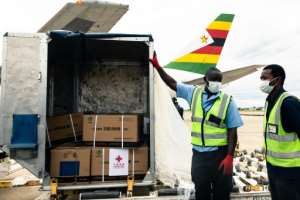 Workers unload part of a 200,000-dose shipment of the Sinopharm coronavirus vaccine from China.  By Jekesai NJIKIZANA (AFP / File)