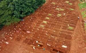 Workers prepare a burial site for a victim of the COVID-19 coronavirus at a cemetery in Jakarta. By BAGUS SARAGIH (AFP)