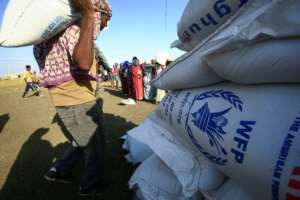 Workers unload World Food Programme food aid at the 'Village 8' reception facility on Friday. By ASHRAF SHAZLY (AFP)