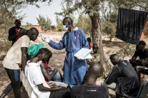 Young homeless men who once were street children get their temperatures measured as part of efforts to curb coronavirus. By JOHN WESSELS (AFP)
