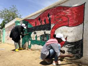 Young Sudanese paint a national flag on a wall in the capital Khartoum. By ASHRAF SHAZLY (AFP)