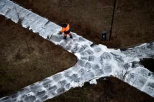 A municipal worker cleans and disinfects walkways in a yard in Moscow, during the strict lockdown in Russia. By Natalia KOLESNIKOVA (AFP)