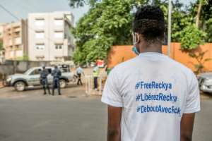 A Madougou supporter outside the CRIET court in Porto-Novo, as security forces look on. By Yanick Folly (AFP)