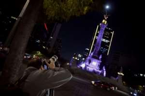 A man taking pictures of the Super Moon during the start of the total lunar eclipse, at the Angel de la Independencia in Mexico City.  By ALFREDO ESTRELLA (AFP)