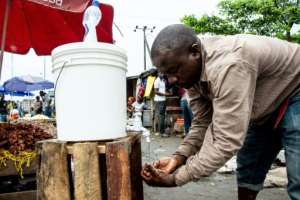A man washes his hands with chlorinated water at Mabibo market in Dar es Salaam. By Ericky BONIPHACE (AFP)