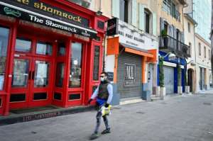 A man wearing a face mask walks past closed bars and restaurants in Marseille, southern France. By GERARD JULIEN (AFP)