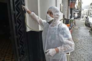 A man disinfects a building in Algiers. By RYAD KRAMDI (AFP/File)