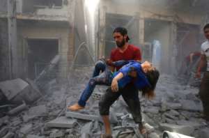 A man evacuates a young bombing casualty after a reported air strike by Syrian forces and their allies in the jihadist-held town of Maaret Al-Noman in Idlib province in May 2019 -- more than 370,000 people have beem killed in the conflict. By Abdulaziz KETAZ (AFP/File)