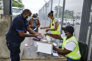 A man gets his hands sanitised before entering South Africa -- but pandemic-related testing and associated paperwork have created a huge backlog. By Guillem Sartorio (AFP)