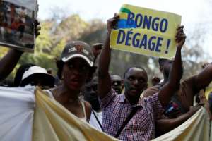 A man holds a placard reading,