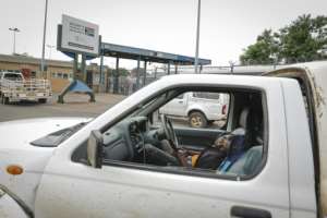 A man looking to cross the border sleeps inside his pick-up truck -- the coronavirus has complicated crossings which can take days. By Guillem Sartorio (AFP)