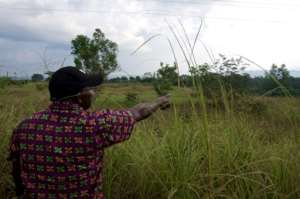A man points at an old uranium extracting shaft in Mounana, Gabon, where hundreds of men used to work