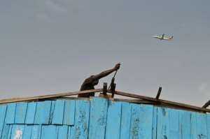A man removes the roof of his house in Adjouffou. Authorities announced the security perimeter after a 14-year-old boy scaled a fence to climb onto the landing gear of a departing jetliner -- his tragic death also triggered a security alert. By ISSOUF SANOGO (AFP)